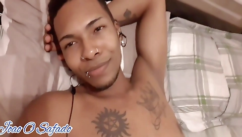 Ebony blonde girl with a tattooed body is alone on bed